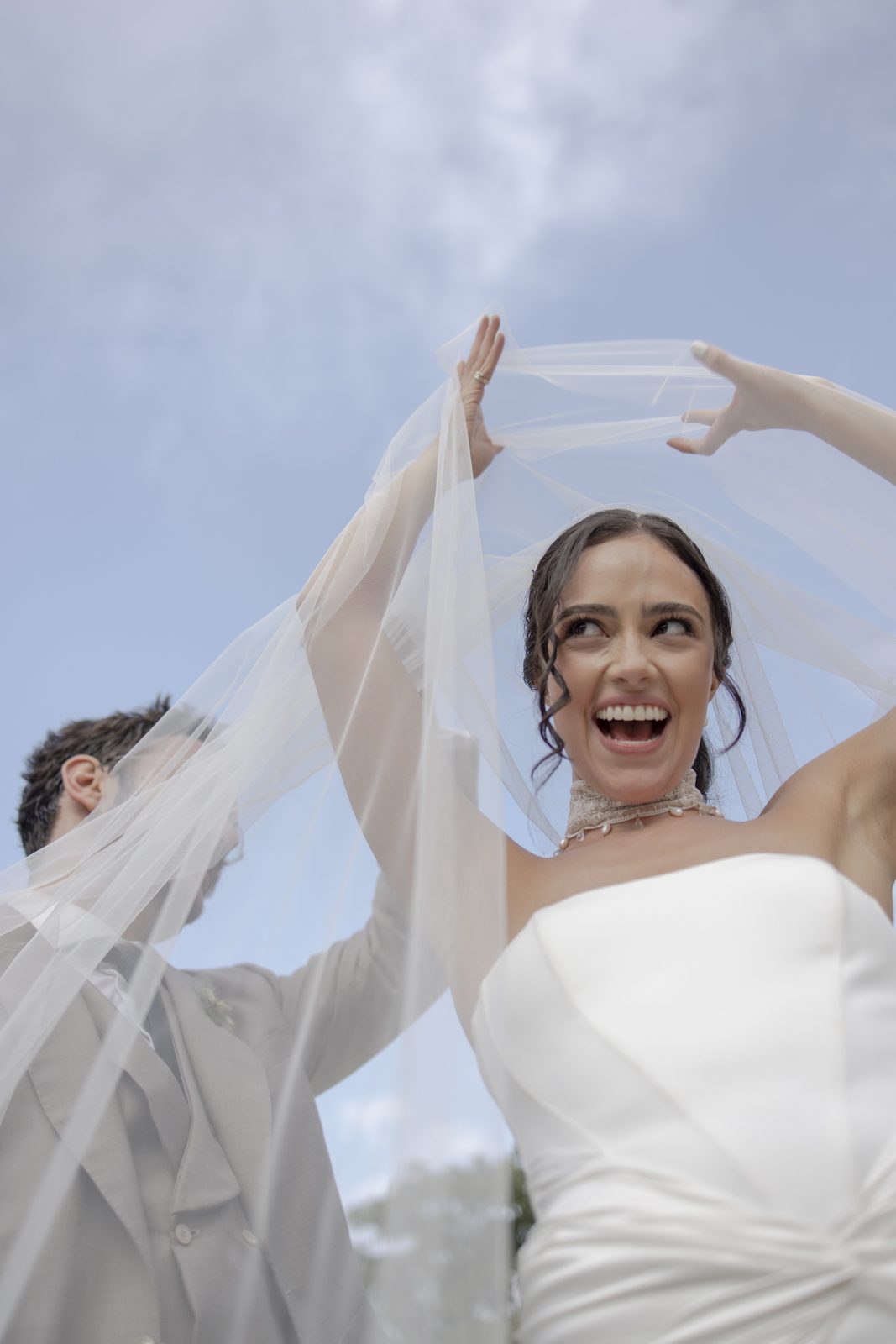 A joyful bride lifting her veil