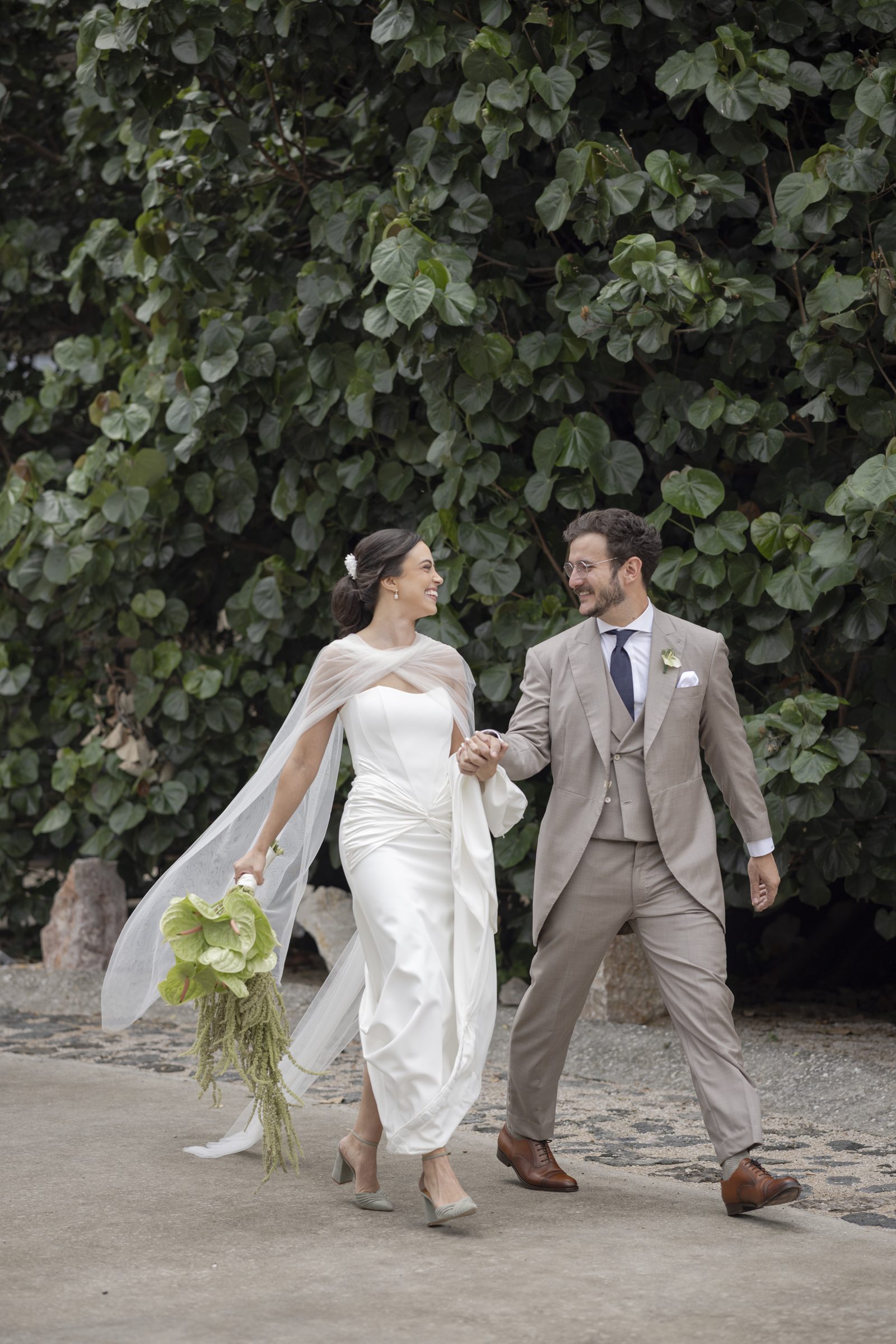 Couple walking by a wall of greenery