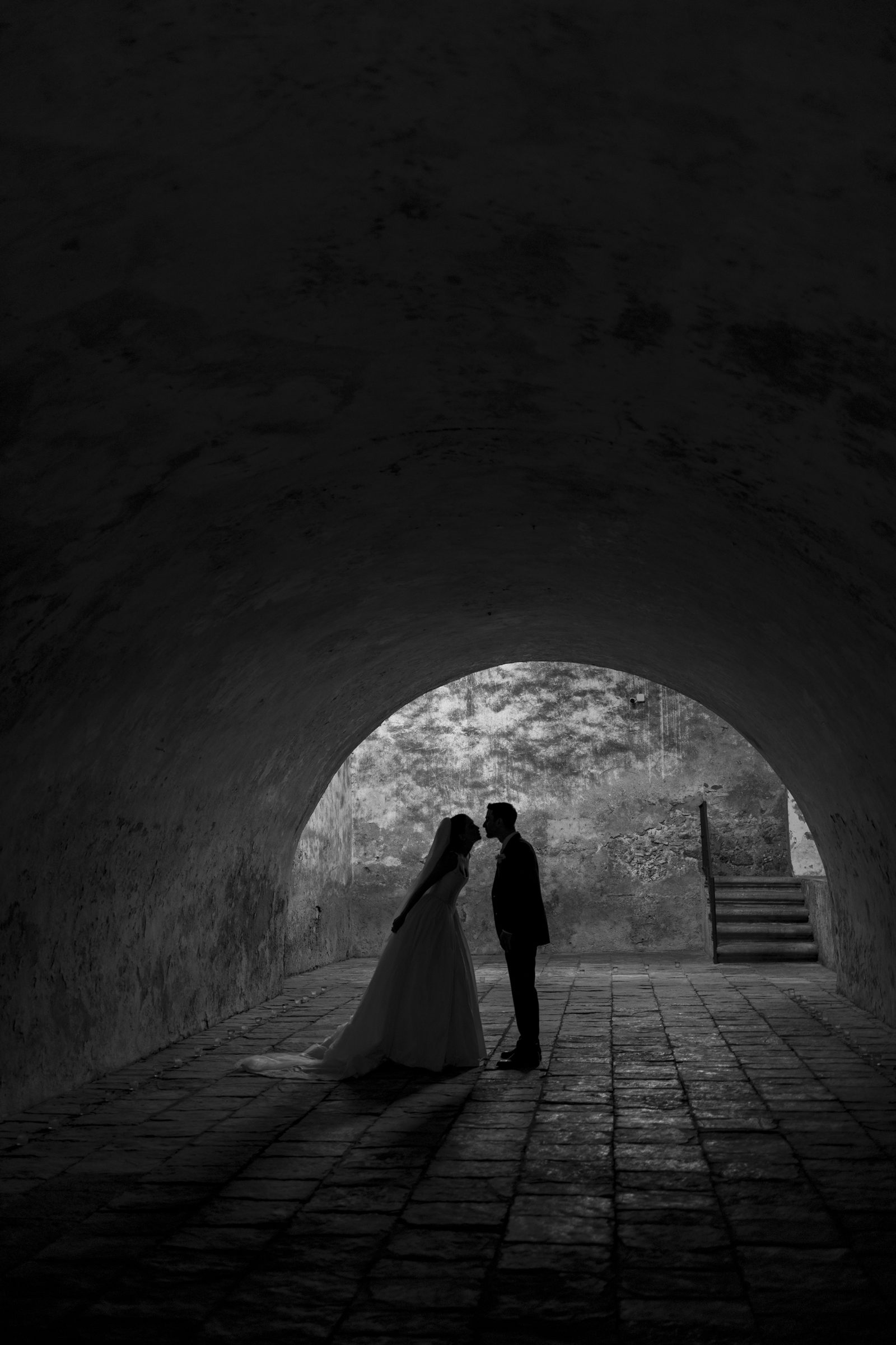 A couple beneath a stone archway
